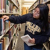 library student employee shelving a book