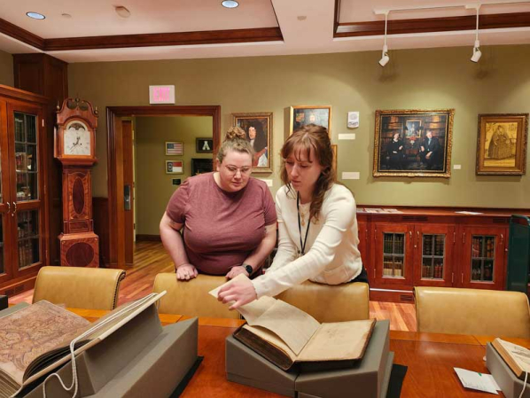 Hannah Helmey sharing book with Jecca Hodges for Open House