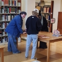 Artist and students observing a pop up book open on a table in the SCRC