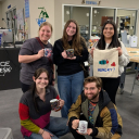 Photo of students holding mugs and a canvas tote created in the App State Makerspace