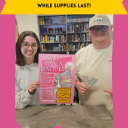 two students in the music library holding an event poster and 2 tickets