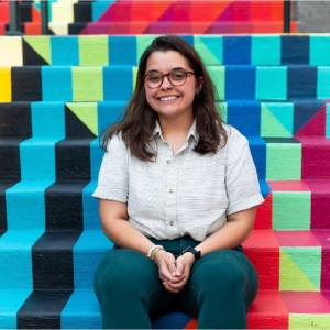 Krystal Carter seated on the brightly colored painted steps of the Turchin Center