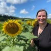 Image of Sharon Taylor standing in a field of sun flowers