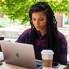 Student workingon laptop on library patio