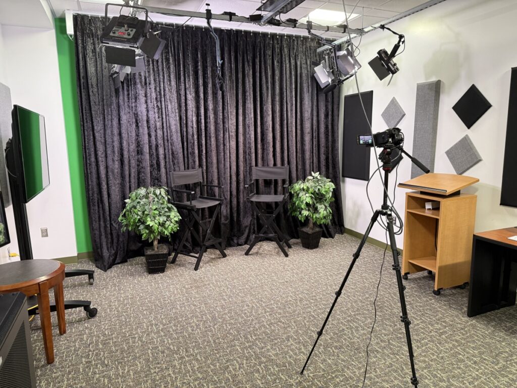 Recording studio interior with black velvet curtain backdrop and two director's chairs